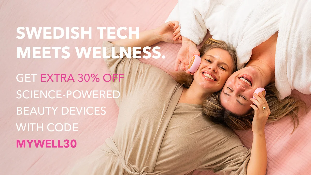 Global wellness day, two women lying on their back head to head enjoying a wellness moment together on pink background